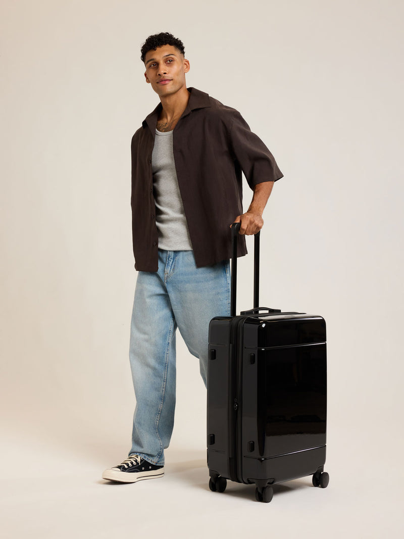 Model with CALPAK Hue Medium Luggage in Glazed Black