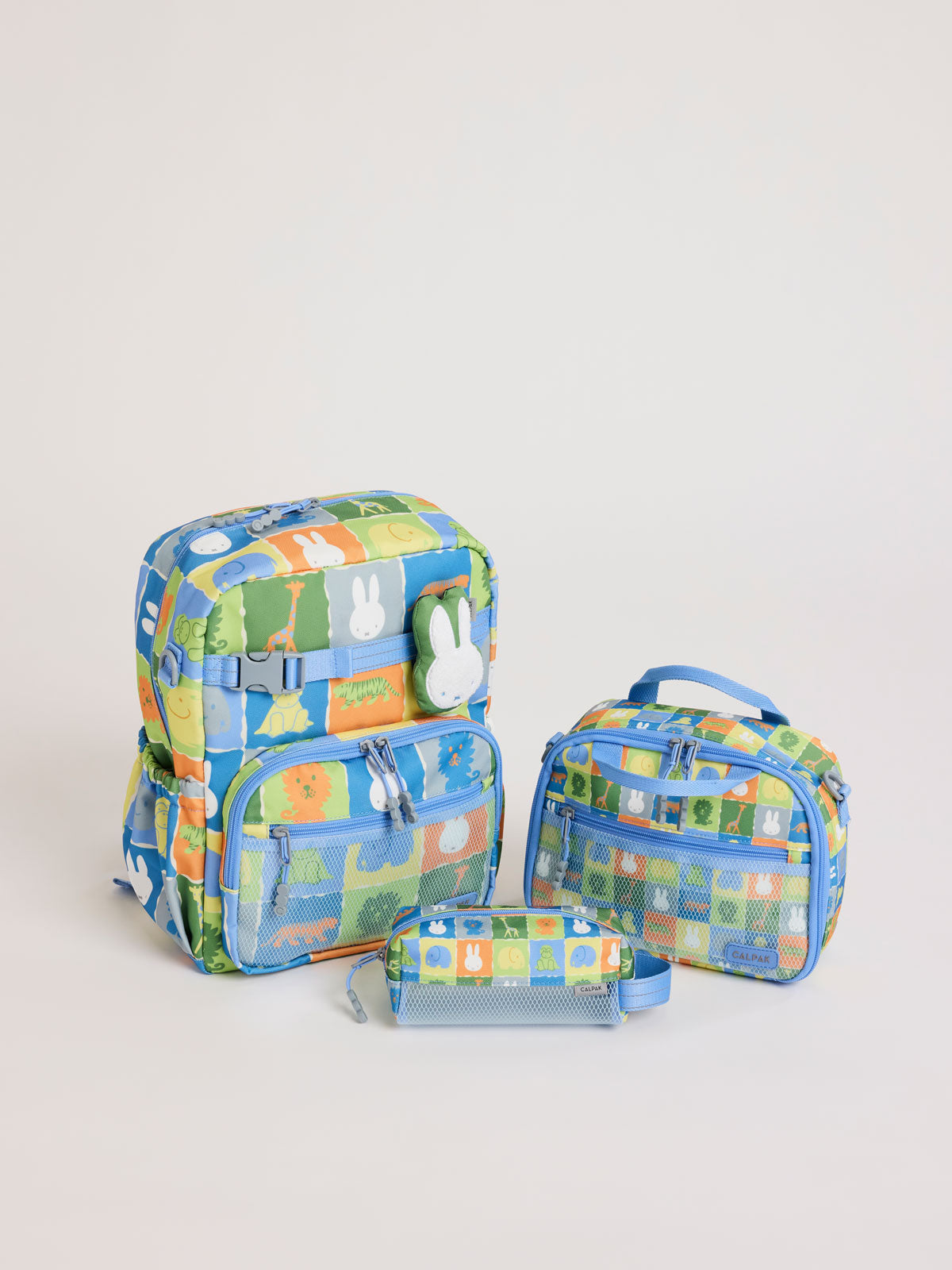 Colorful CALPAK + Miffy Kids Essentials Set with children's Medium backpack, lunch bag , pencil case set on a white background with blue accents and Miffy with other animals; BCKM5000-MIFFY-BLUE-ZOO-TRIP