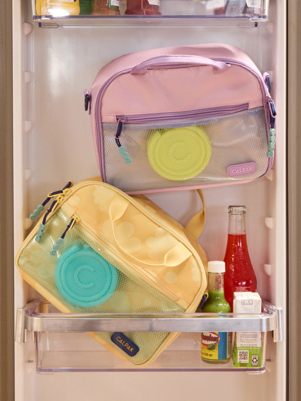 CALPAK circular Ice Packs that comes in a set of 2 in blue and yellow with letter C initial in the middle inside lunchbags; AIP2501-AQUA-YELLOW