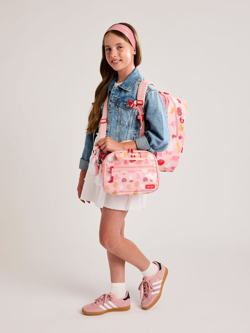Girl with a CALPAK Kids Large Backpack with Miffy and pink colorful animal pattern on a white background