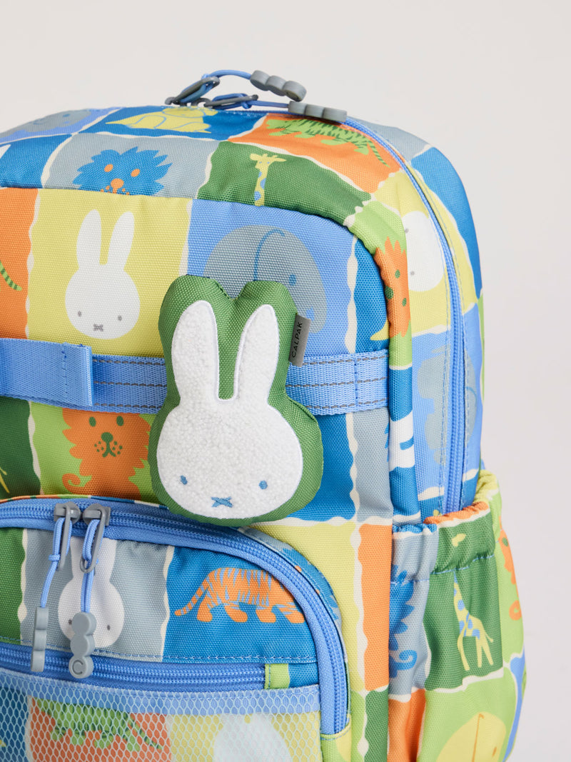 Plush Miffy x CALPAK Pluffy Bag Charm keychain with a green border and Miffy attached to a colorful children CAKPAK Kids Backpack