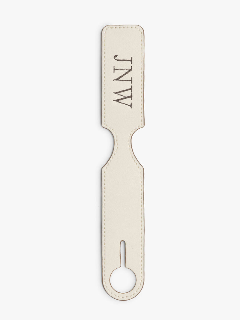 CALPAK Personalized Luggage Tag in beige Buttercream personalized with initials "JNW" laid flat on a white background