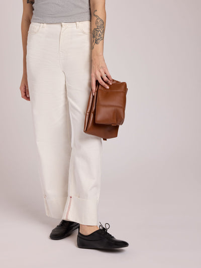 CALPAK light brown Honey Brown vegan leather pouch bag with a structured rectangular shape and vertical stitched panel details, shown against a plain white background; ZLPM2601-HONEY-BROWN-PU view 2
