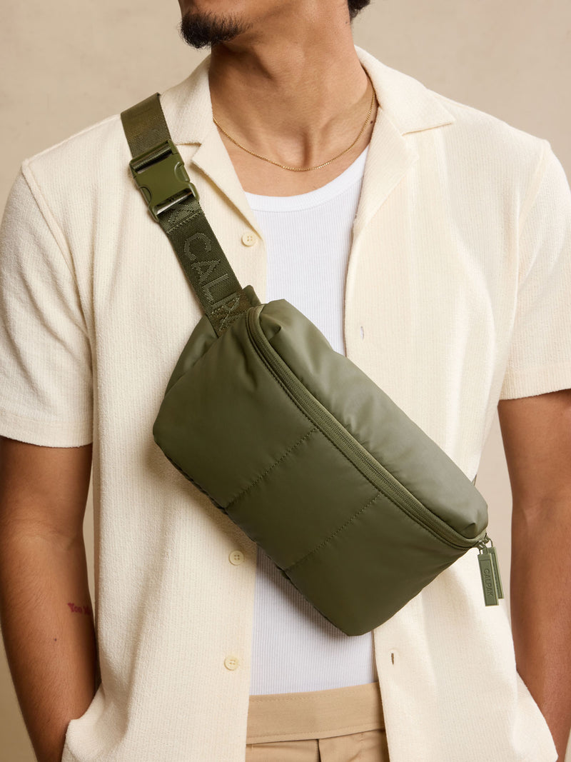 Model wearing CALPAK Luka Belt Bag in dark green Pine front view