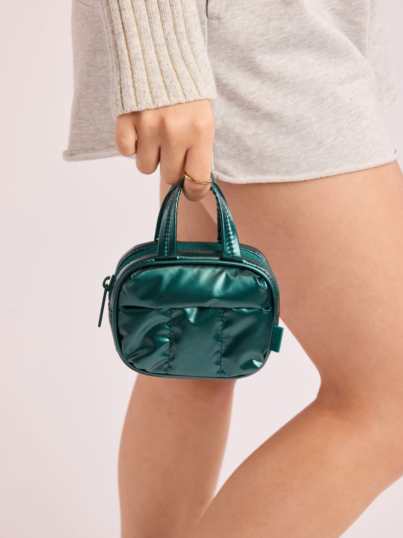 Model holding CALPAK Luka Duffel Zip Bag Charm in dark green shiny Glazed Kale