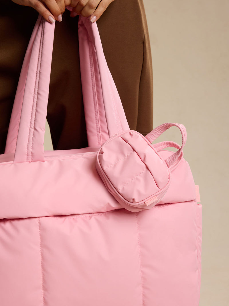 CALPAK Luka Duffel Key Pouch attached to a bag, held by a person against a neutral background