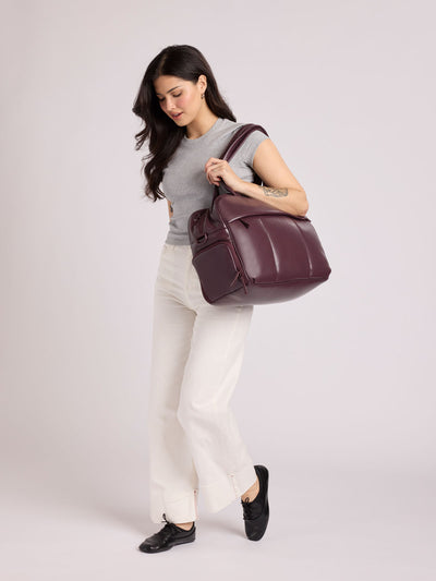 A dark burgundy CALPAK Luka Duffel in vegan leather with dual top handles and a front zippered pocket, photographed against a clean white background; DSM1901-DARK-CHERRY-PU view 2