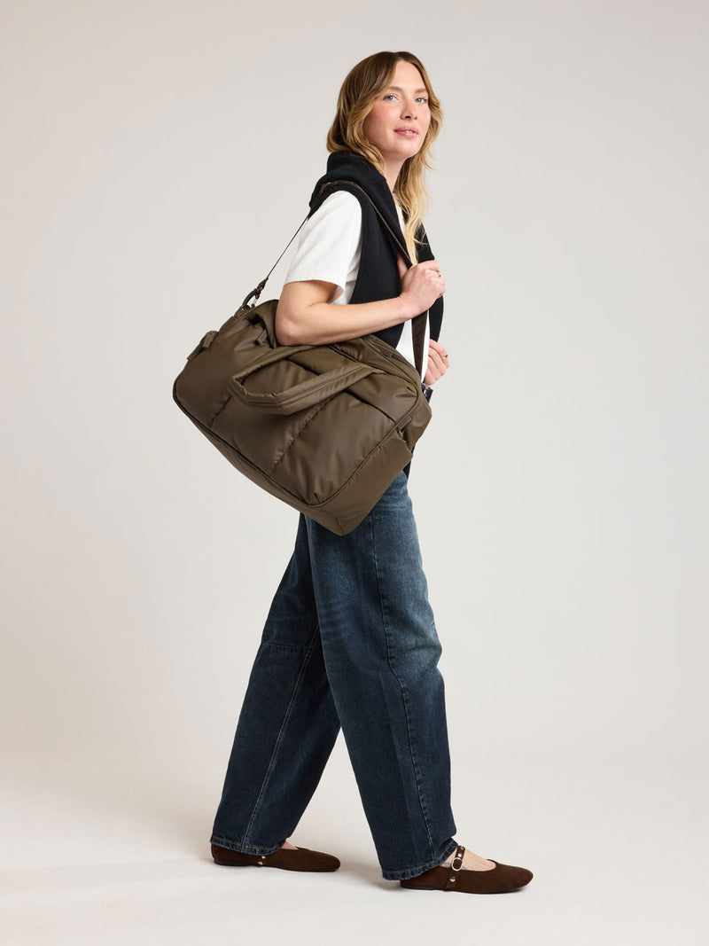 Person with CALPAK Luka Duffel in brown Mushroom