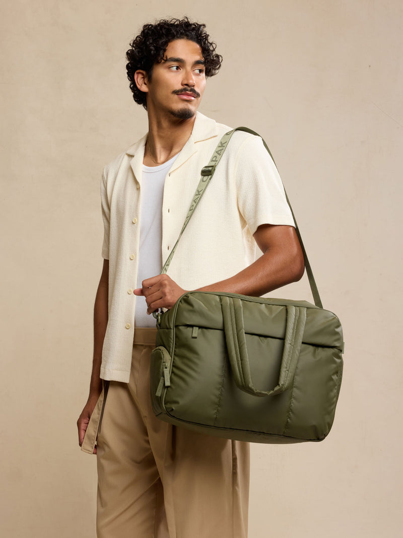 Male model wearing CALPAK Luka Duffel in dark green Pine