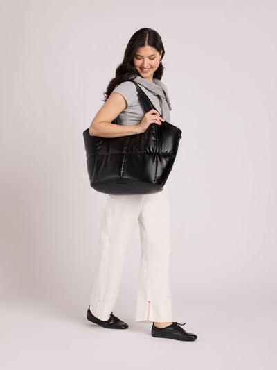 Black quilted puffer CALPAK Luka Everything Tote Bag with a smooth finish and double shoulder straps, shown against a plain white background; AET2601-BLACK-PU view 2