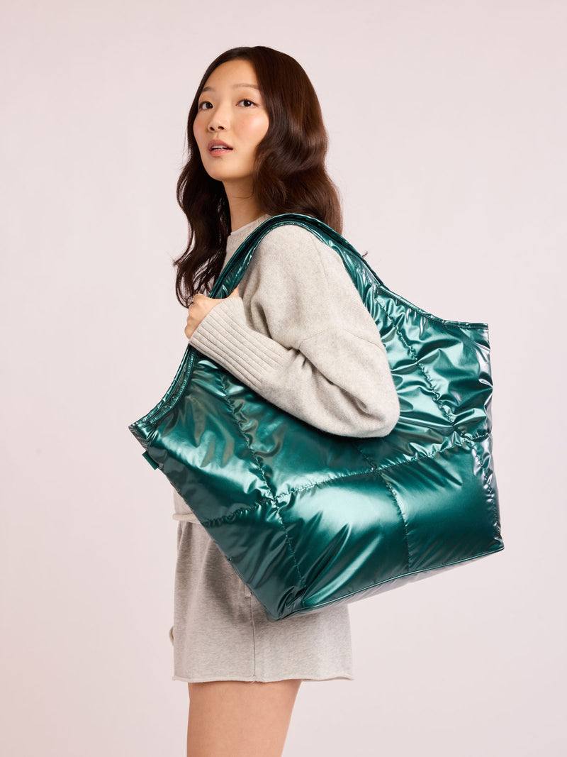 Woman wearing CALPAK Luka Everything Tote in dark green shiny Kale
