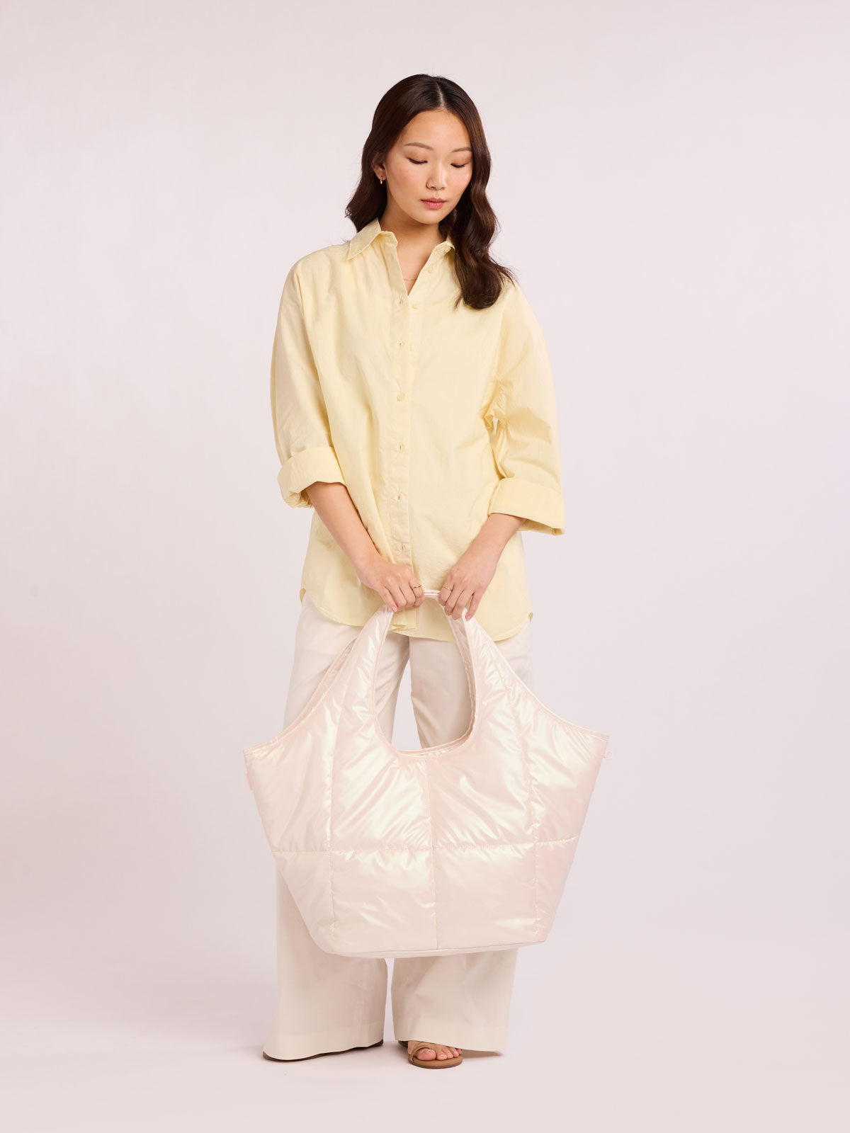 Woman holding CALPAK Luka Everything Tote in light pink Pearlescent; AET2601-PEARLESCENT