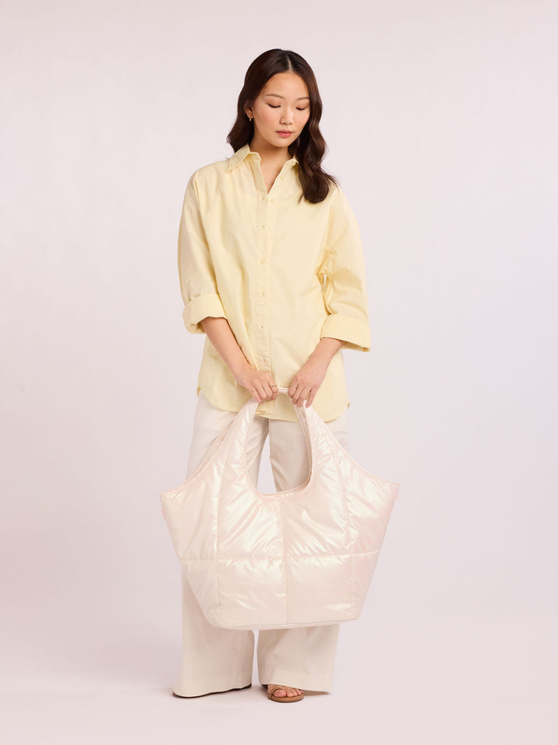 Woman holding CALPAK Luka Everything Tote in light pink Pearlescent