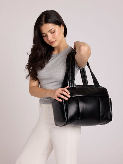 Black vegan leather CALPAK Luka Mini Duffel with dual top handles and side pockets, photographed against a clean white background; DLM2501-BLACK-PU view 2