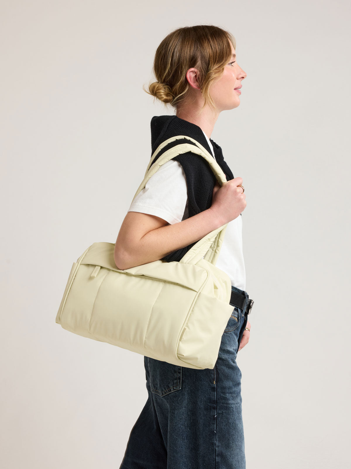 Model wearing CALPAK Luka Mini Duffel in light green Celadon; DLM2501-CELADON