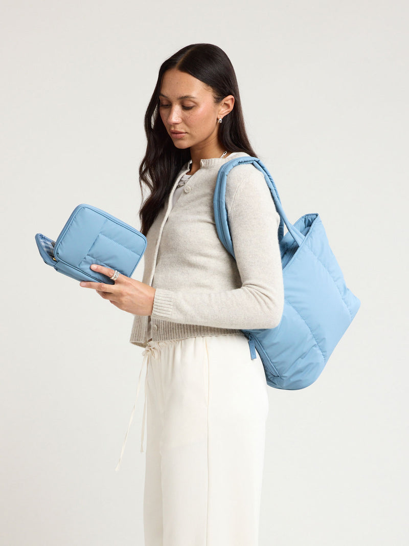 Woman wearing the CALPAK Luka Mini Tote in light blue French Blue