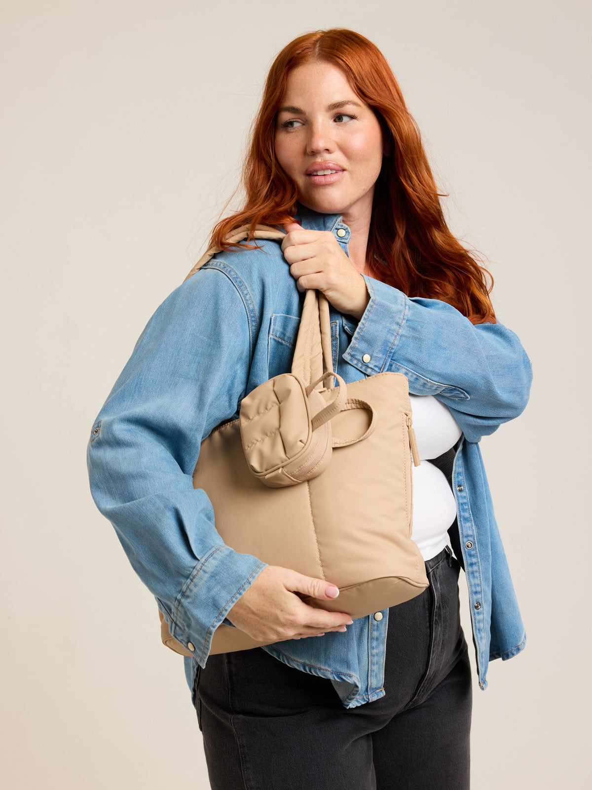 Model with CALPAK Luka Mini Tote in beige Latte on a white background; ALM2401-LATTE
