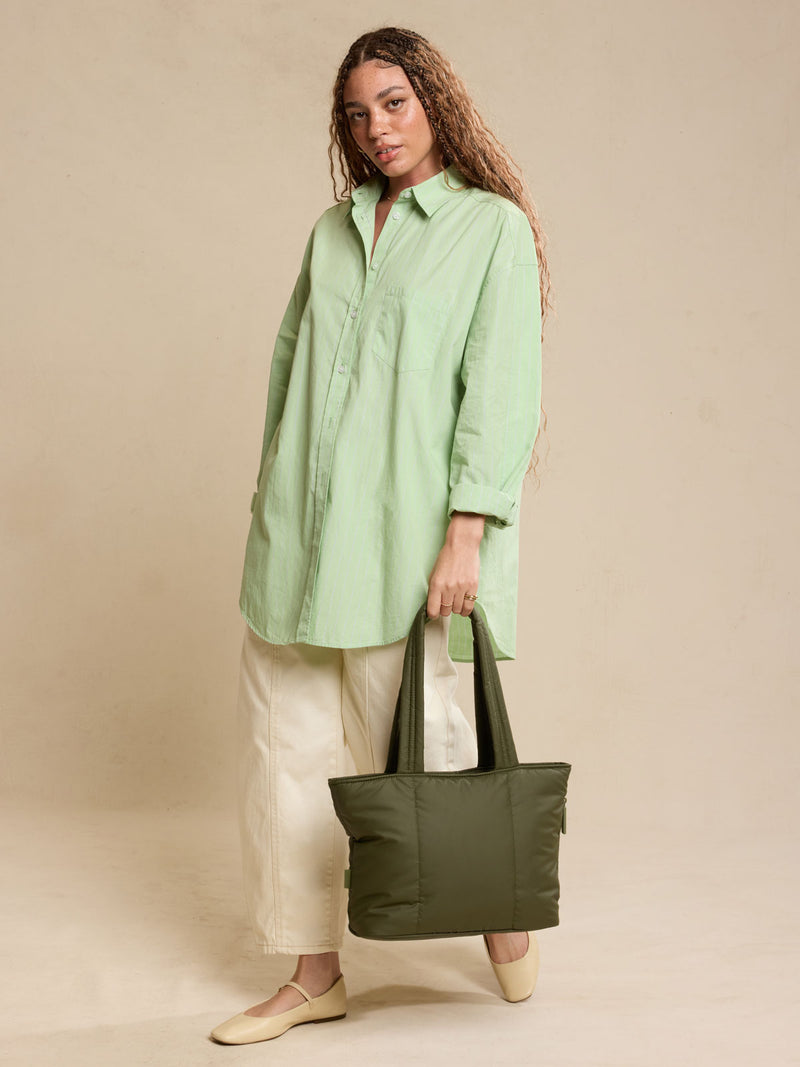 Model holding CALPAK Luka Mini Tote in dark green Pine