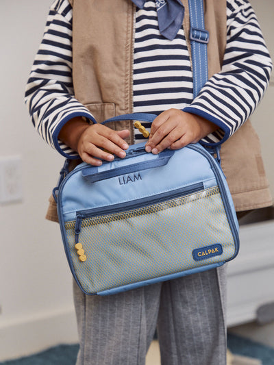 CALPAK Kids Lunch Bag in Blue front view with dark blue zippers and yellow mesh front pocket, water-proof lining, insulated, multiple interior pockets, and back name tag; CKLB2501-BLUE  view 2