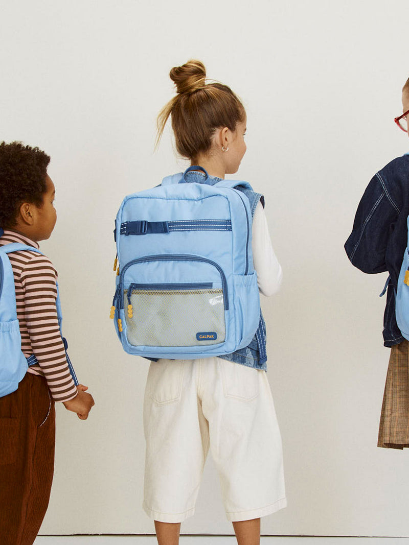 CALPAK Kids Medium Backpack in Blue for ages 5-8 being worn by children for school