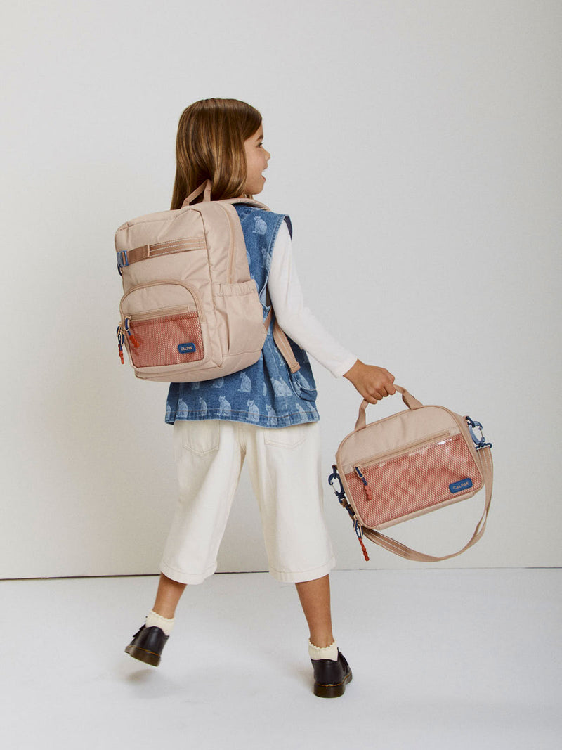 CALPAK Kids Medium Backpack in brown/tan Khaki for ages 5-8 being worn by child holding a CALPAK Kids brown/tan Khaki Lunch Bag