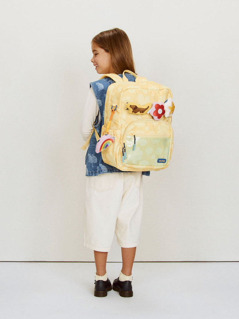 CALPAK Kids Medium Backpack in yellow floral Yellow Bloom for ages 5-8 being worn by child