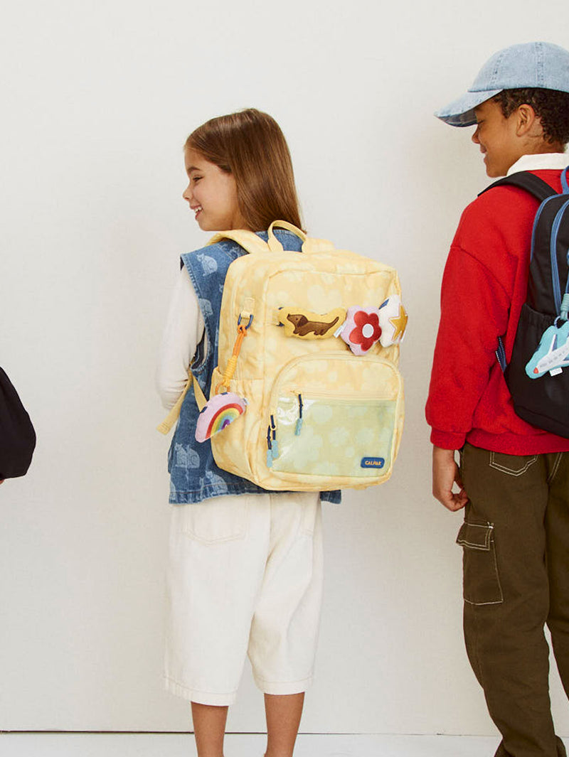 CALPAK Kids Medium Backpack in yellow floral Yellow Bloom for ages 5-8 being worn by child