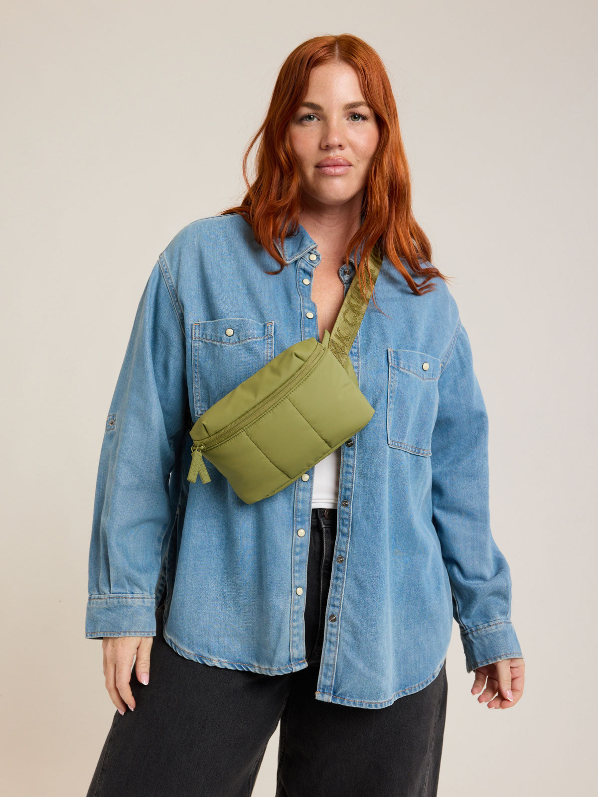 Model wearing CALPAK Luka Mini Belt Bag in dark green Pistachio on white background; BBM2201-PISTACHIO