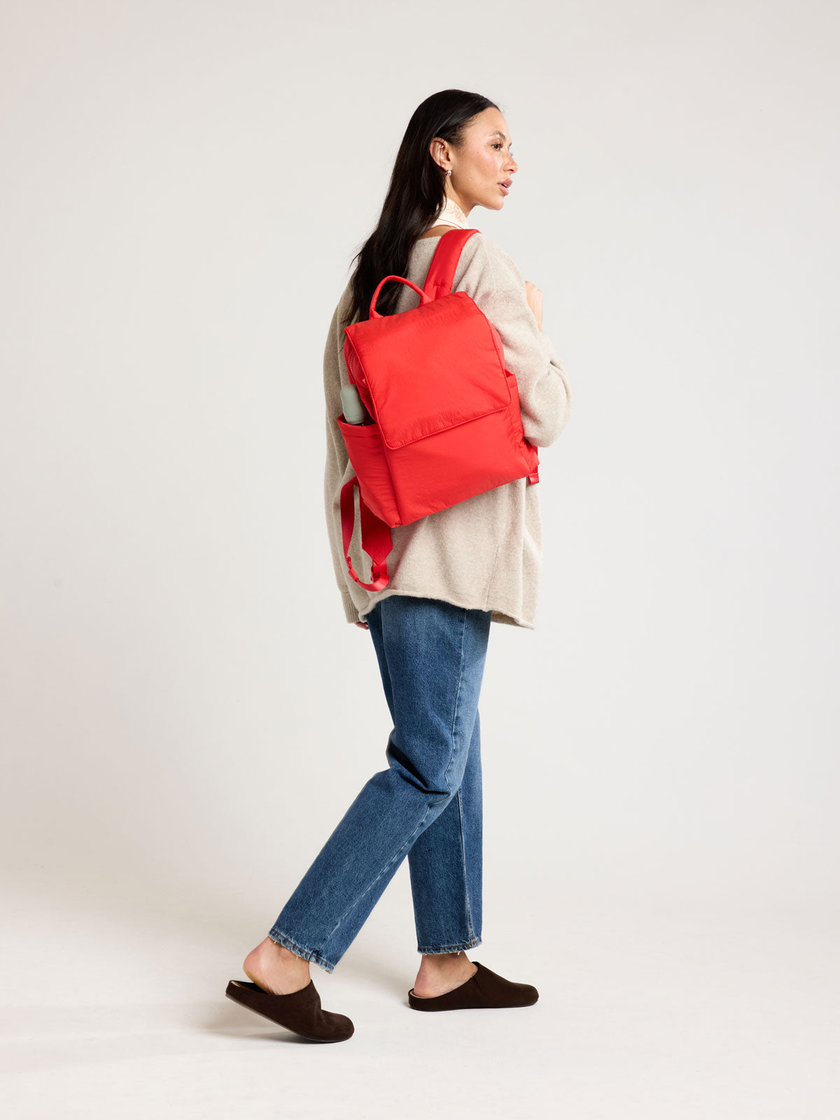 Woman wearing CALPAK Mini Diaper Backpack in red Tomato; BPC2402-TOMATO