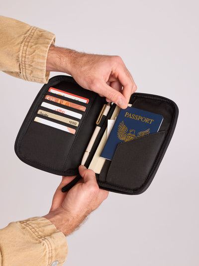  Black CALPAK Luka Zip Passport Wallet in vegan leather with a zippered top and a front pocket, shown on a plain white background; PZW2301-BLACK-PU view 2