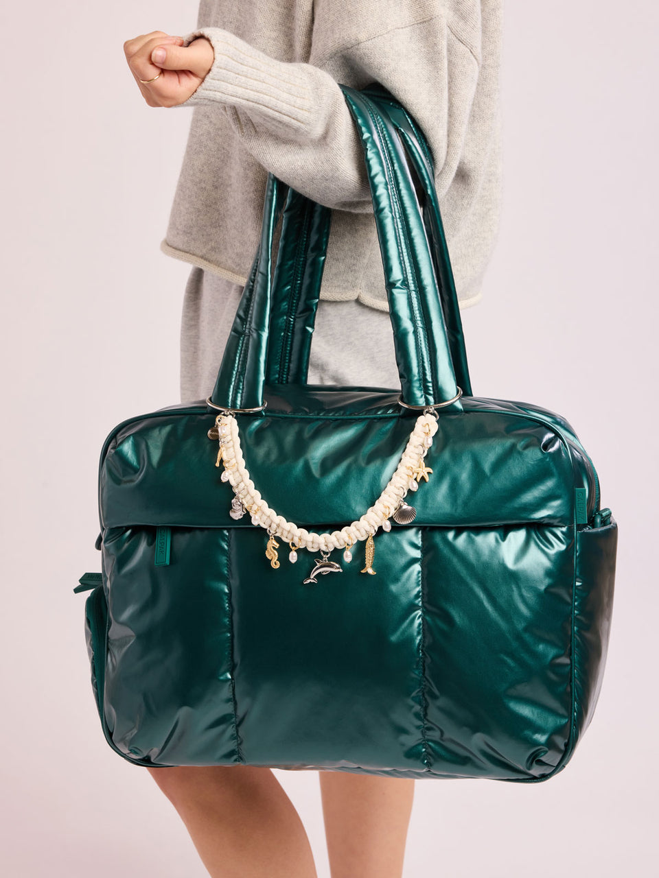 Woman with bag that has CALPAK Rope Bag Charm with white rope and sea shell charms; BCR2601-SEA-LIFE