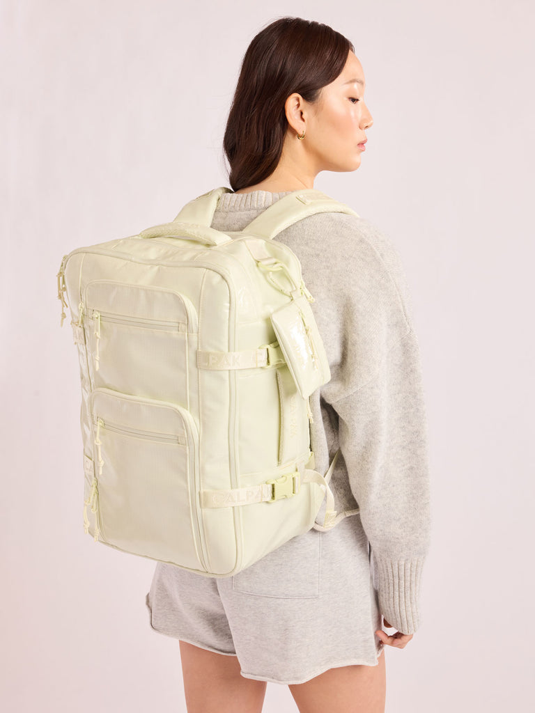 Model in grey wearining the CALPAK Terra 26L Laptop Duffel Backpack with multiple pockets in light green Celadon on a white background; BPH2201-CELADON