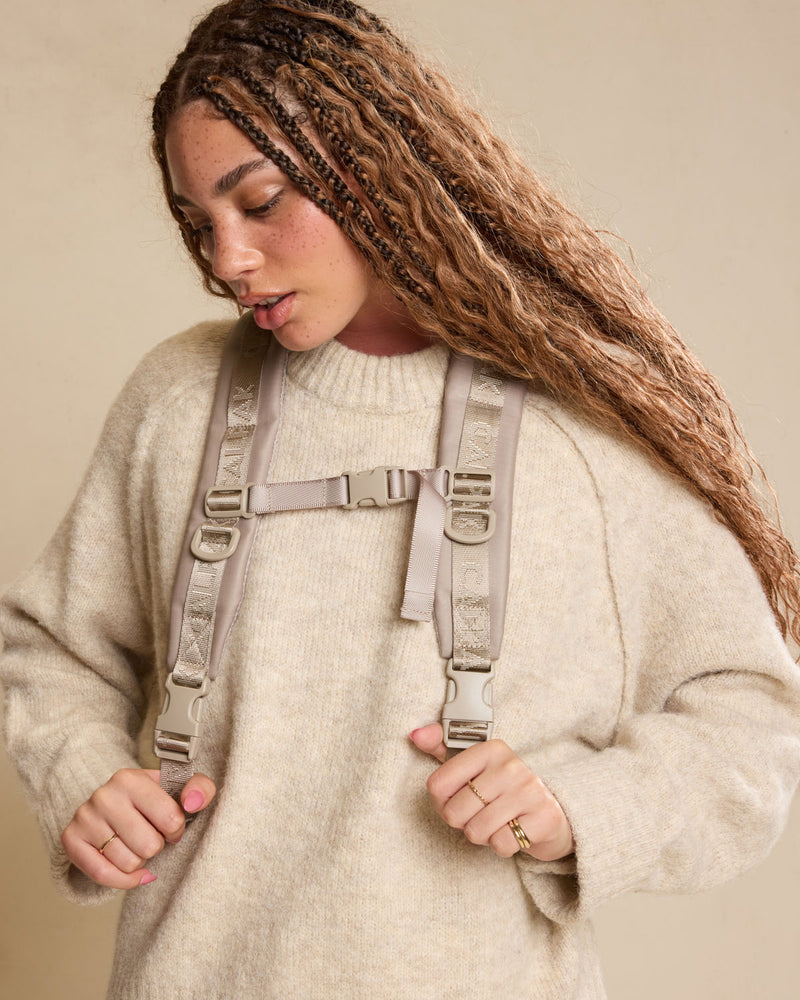 Woman wearing the CALPAK Terra 26L Laptop Duffel Backpack in beige Stone front view; BPH2201-STONE