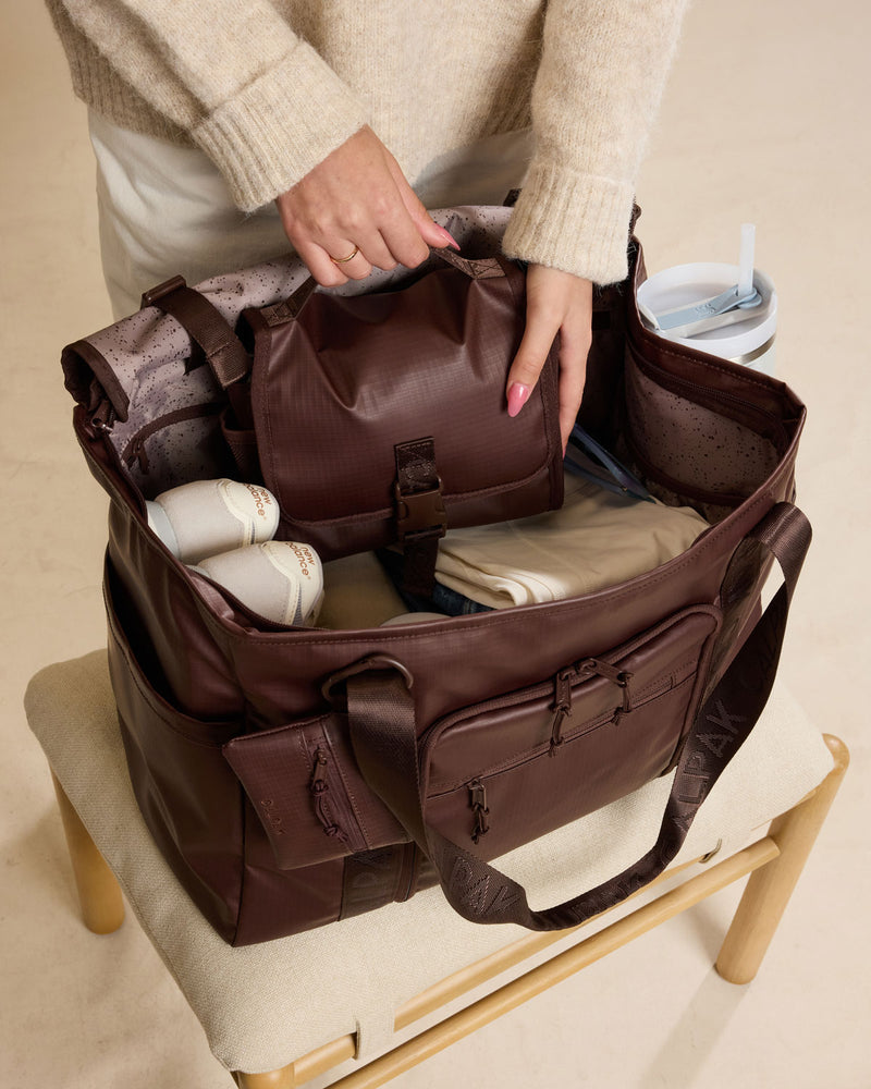 Model packing CALPAK Terra Hanging Toiletry Bag in brown Walnut