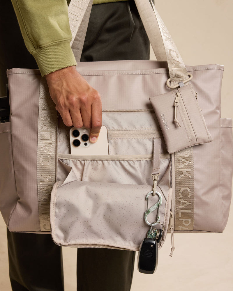 Model using CALPAK Terra 35L Tote in beige Stone front