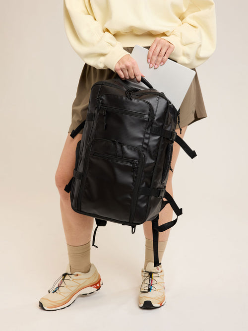 Model with CALPAK Terra 26L Laptop Duffel Backpack in black Matte Obsidian front view; BPH2201-MATTE-OBSIDIAN