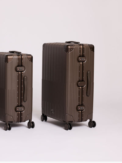 CALPAK Large Vault Luggage in brown Mushroom with hard-shell spinner suitcase with a ribbed vertical design, shown from the front on a light gray background; LVT1028-MUSHROOM view 2