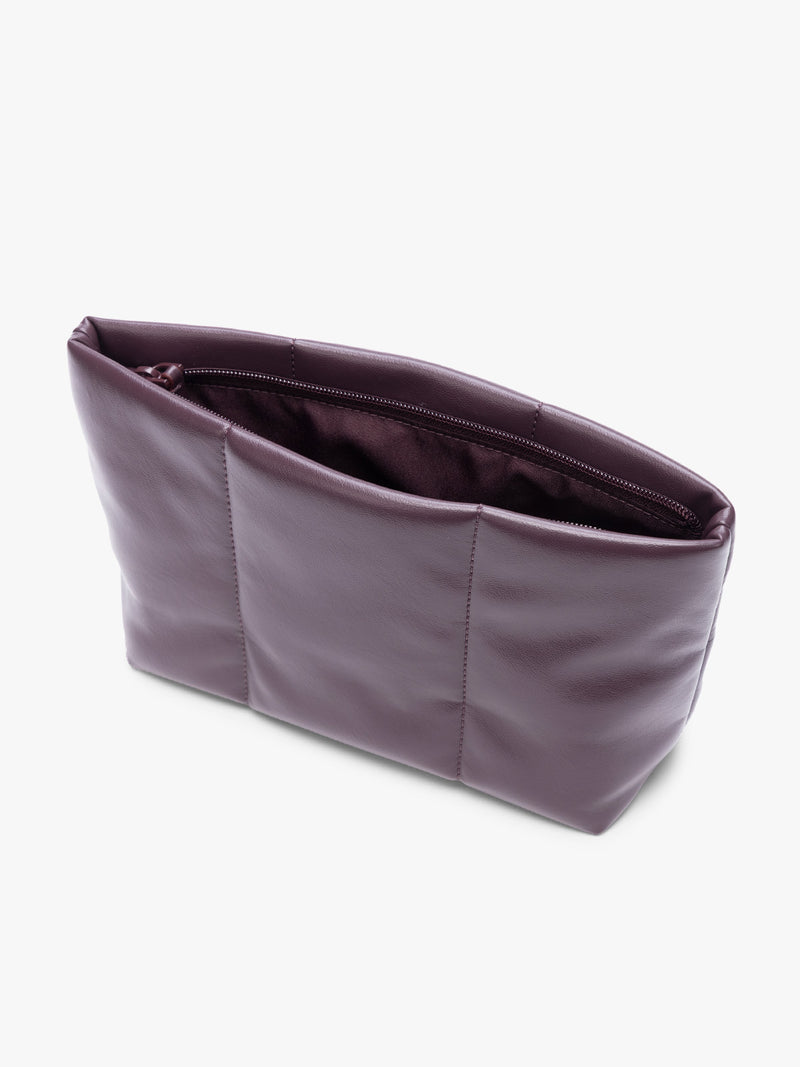 Opened zipper of CALPAK dark red Dark Cherry vegan leather pouch bag with a structured rectangular shape and vertical stitched panel details, shown against a plain white background