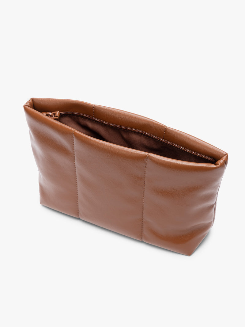 Opened zipper of CALPAK light brown Honey Brown vegan leather pouch bag with a structured rectangular shape and vertical stitched panel details, shown against a plain white background