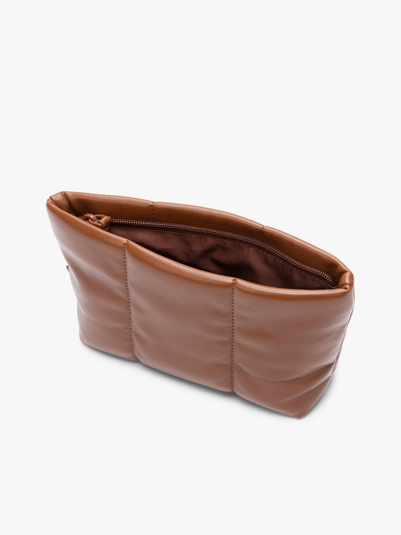 Opened zipper of a CALPAK Luka 1 quart light brown Honey Brown vegan leather pouch bag with a quilted, padded design and a small brand tag on the right side, shown against a plain white background