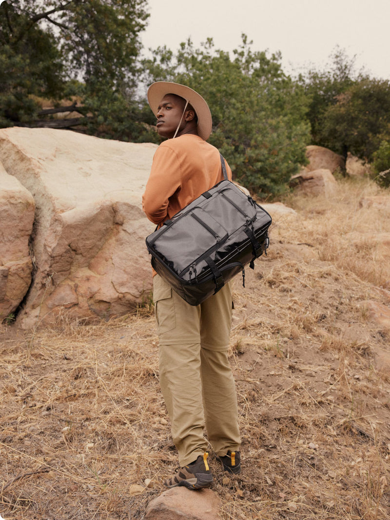 Model on a hiking trail wearing the Terra Backpack in black Obsidian