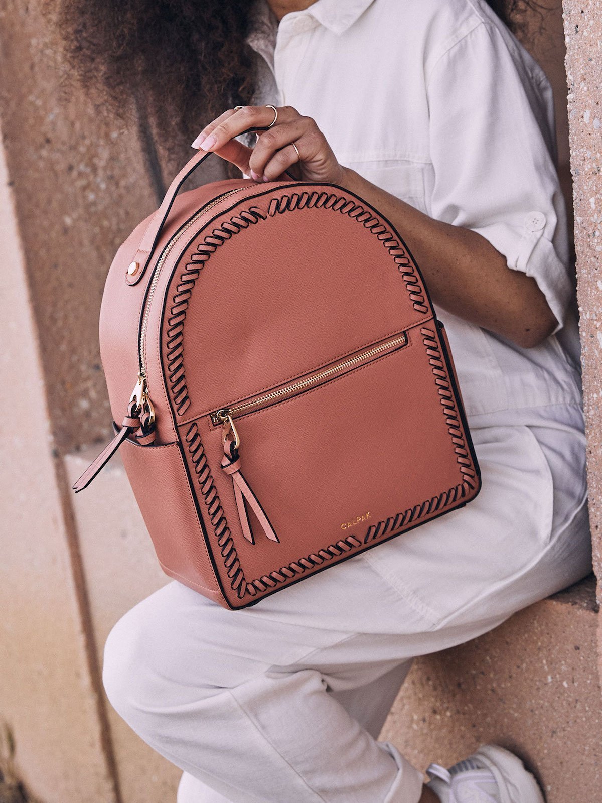 female model with terracotta CALPAK Kaya backpack for women