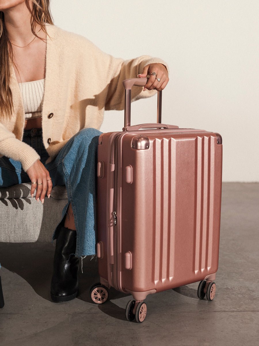 lightweight rose gold CALPAK Ambeur 22 inch rolling spinner carry on luggage