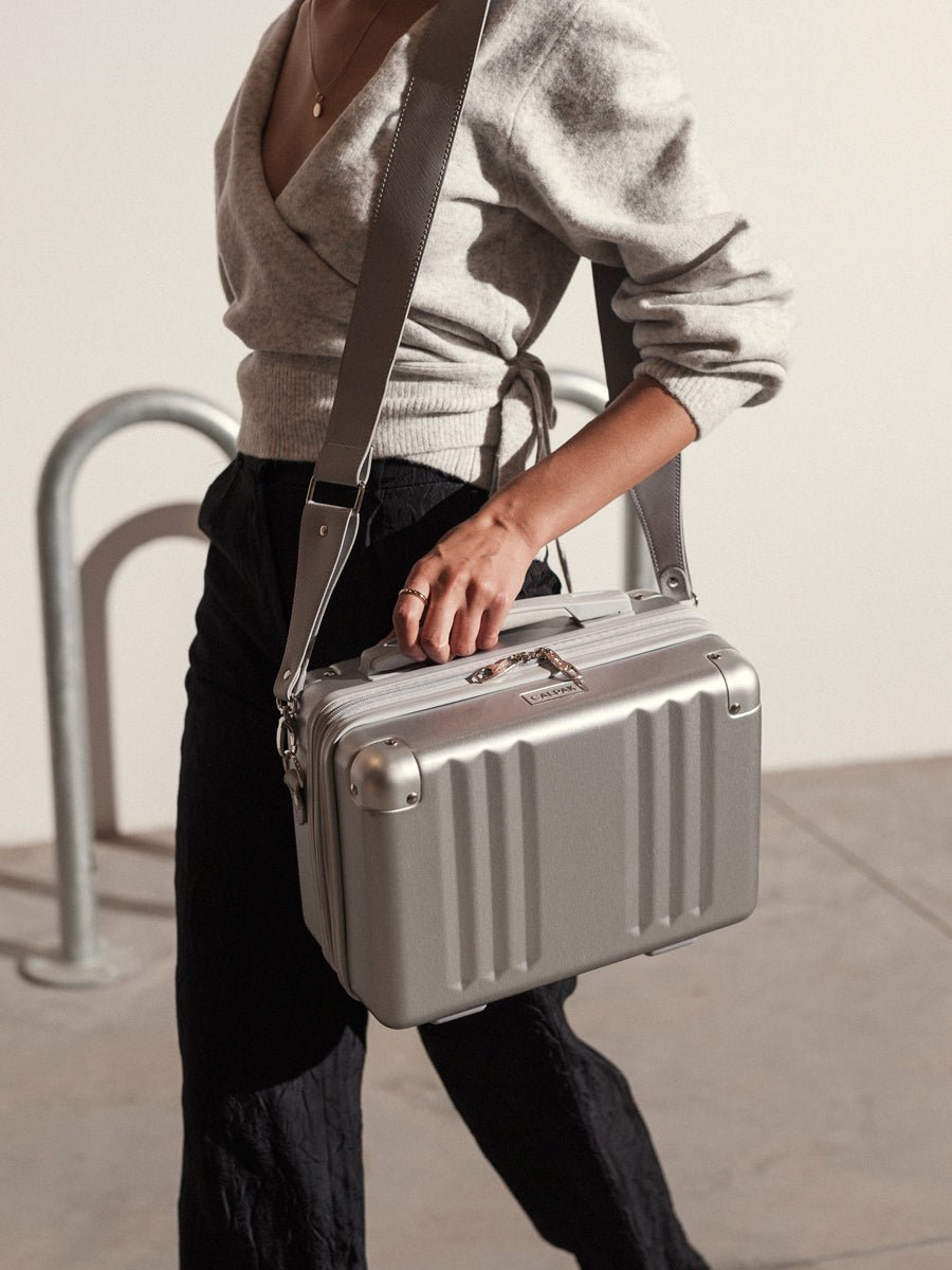 model carrying silver vanity case with shoulder strap