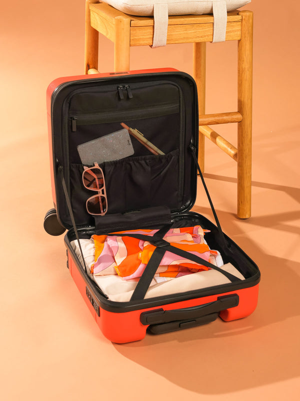 Orange and Pink CALPAK set of organizational pouches for travel being shown in an open Hue Mini Carry-on