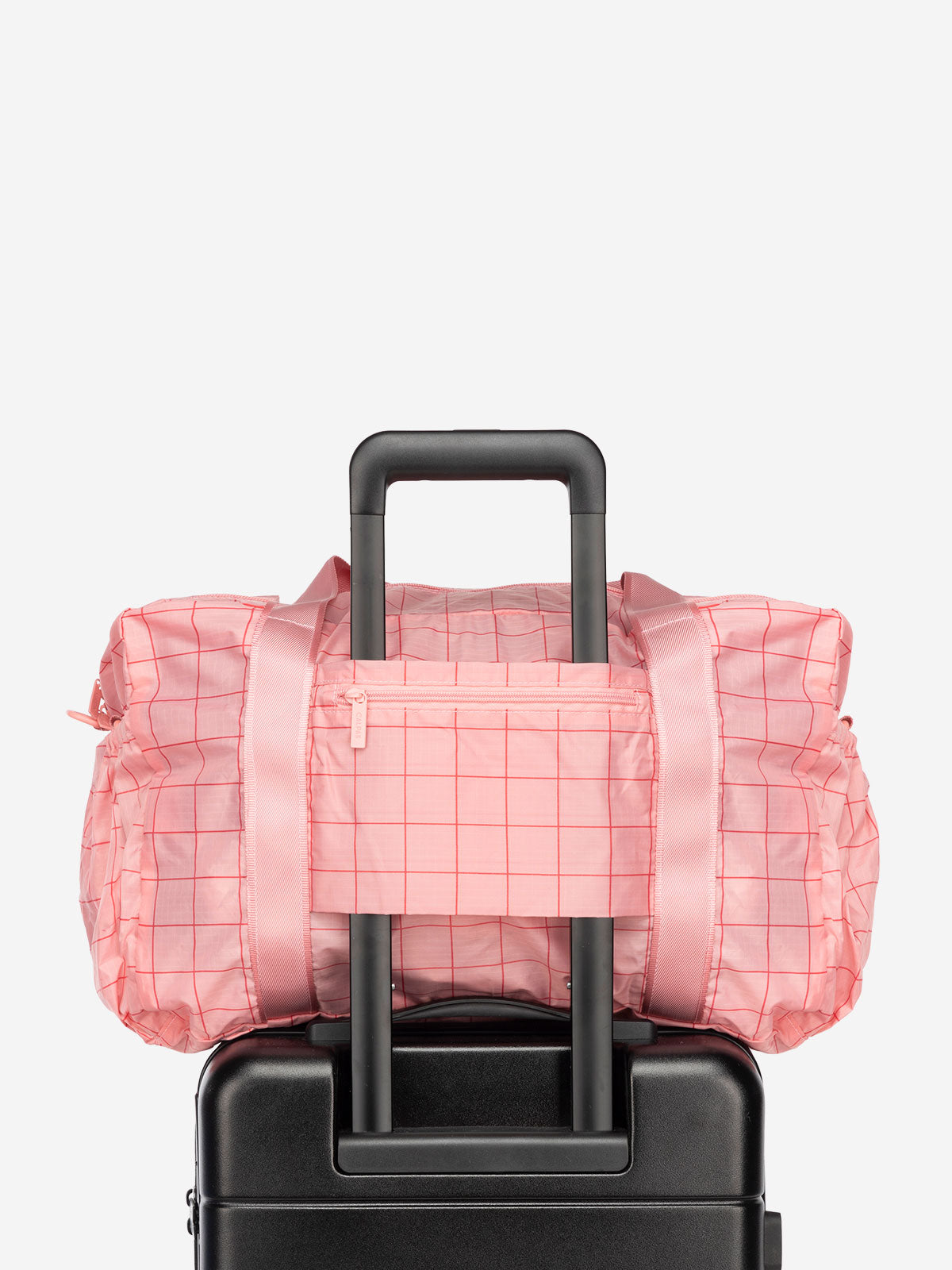 CALPAK Compakt nylon duffle bag with trolley sleeve and zippered pocket in pink grid pattern
