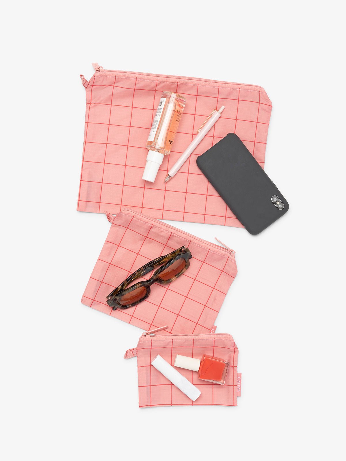 CALPAK Compakt 3 piece zippered pouch set in 3 sizes with water resistant material in pink grid