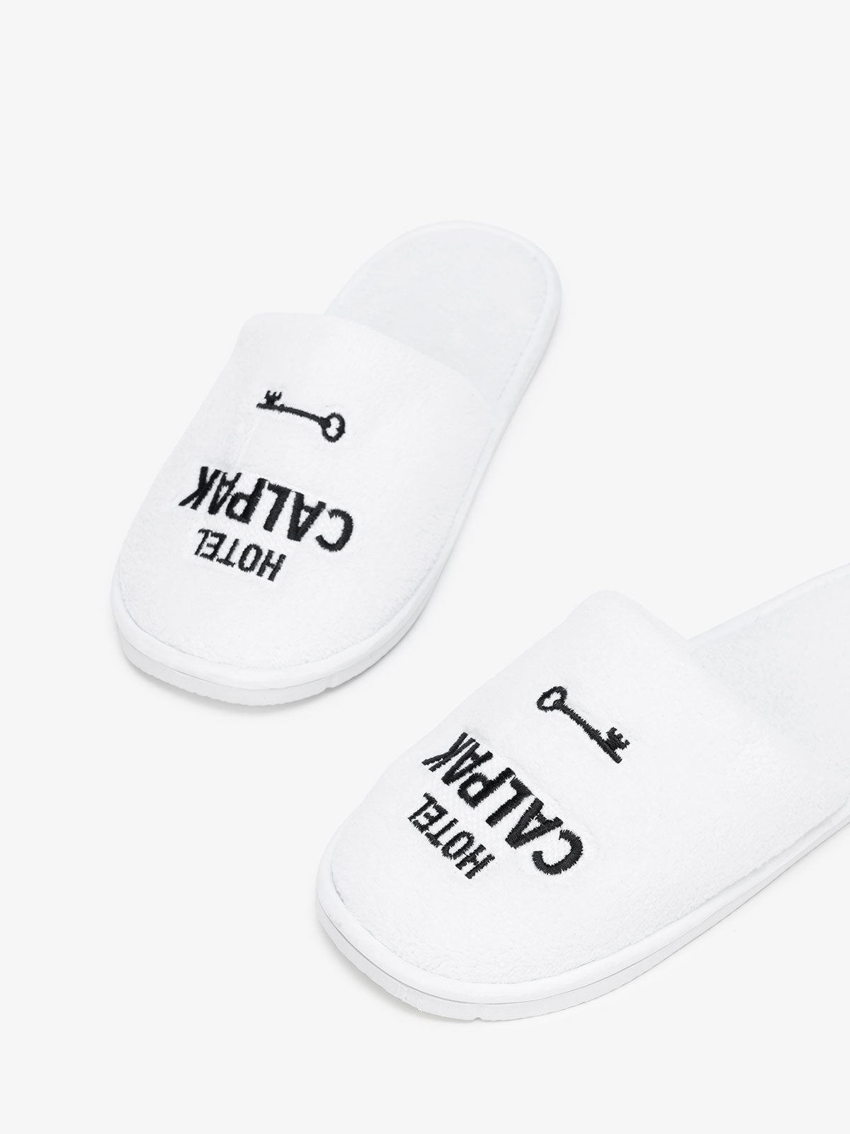 white plush slippers with Hotel CALPAK embroidery