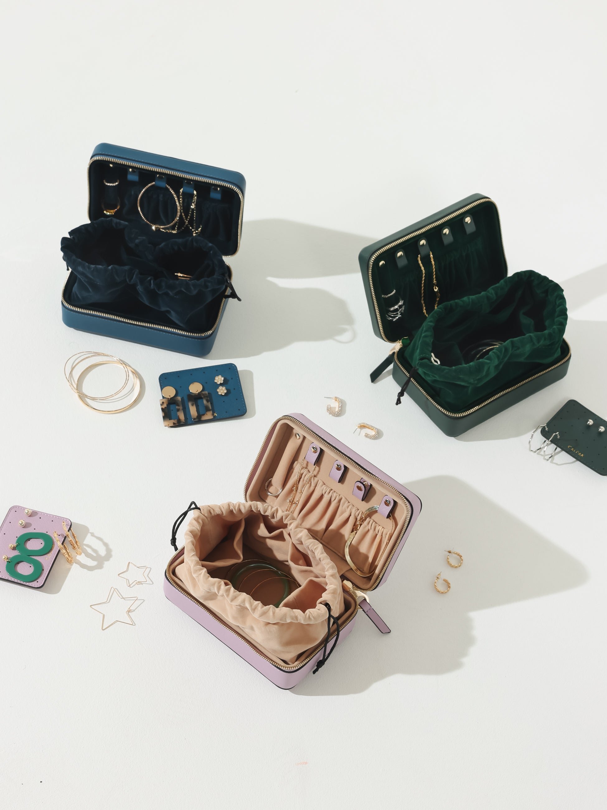 CALPAK zippered jewelry case in deep sea, lavender, and emerald