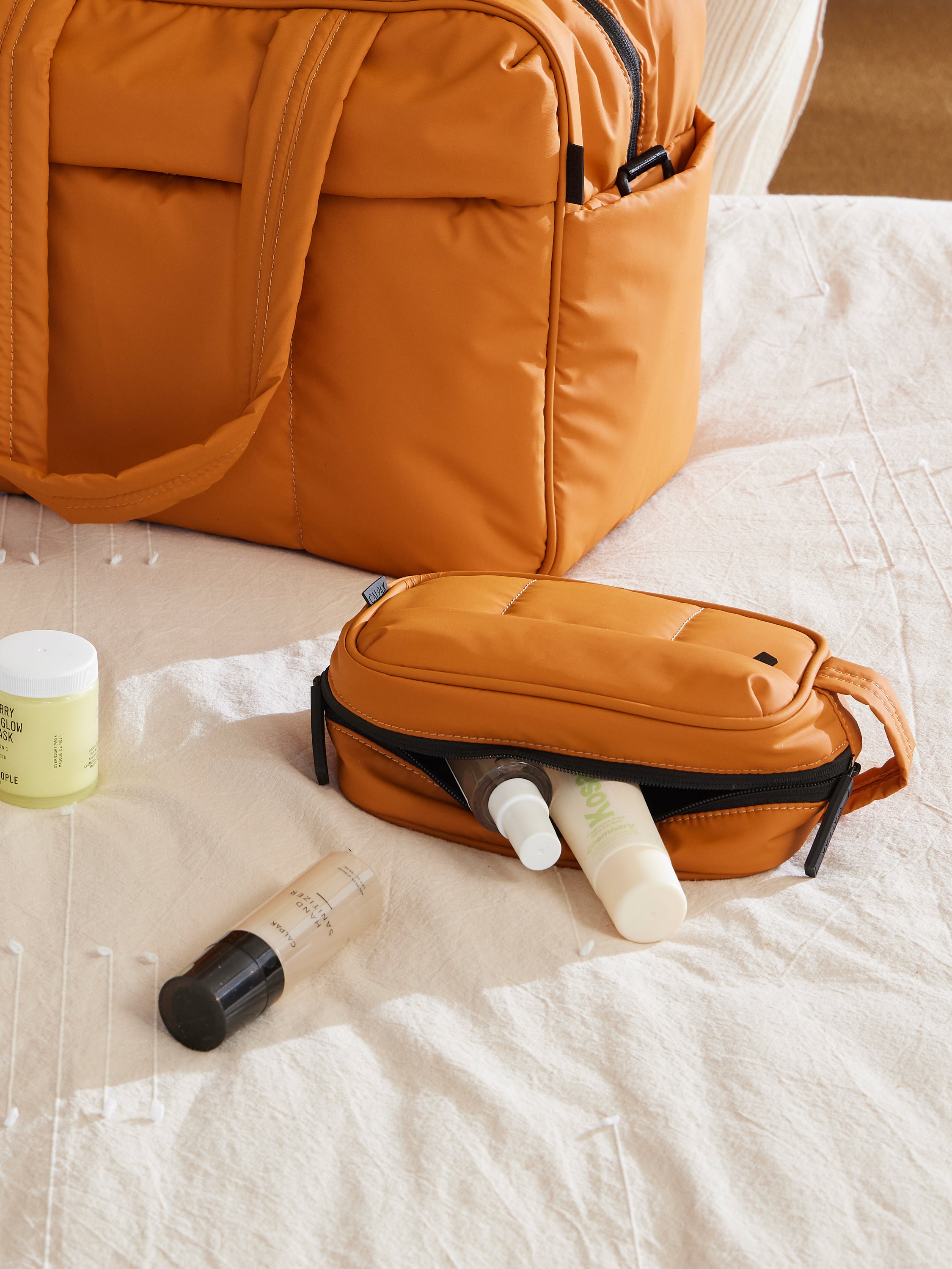 CALPAK Luka Toiletry Bag for skincare and makeup in pumpkin